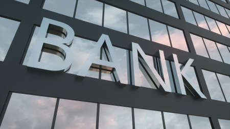 Bank sign on a modern glass skyscraper. Mirrored sky and city on modern facade. Business and finance concept. 3d renderingの写真素材