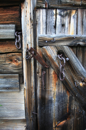 Old vintage rotten wooden door with rusty metal fittingsの写真素材