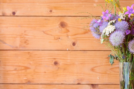 Wooden background, bouquet of purple wildflowers in focusの写真素材