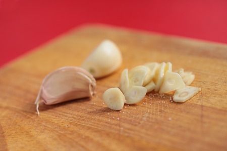 Chopped garlic clove on a wooden board closeupの写真素材
