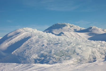 The snowy mountains against the blue sky. Ice desert