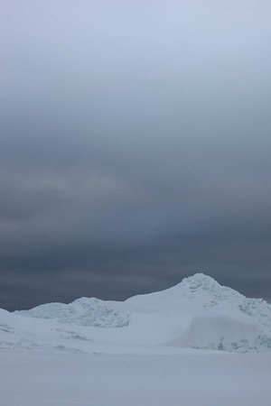 Snowy mountains against a dark dramatic winter sky