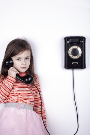 Portrait of a girl talking on phone on white backgroundの写真素材