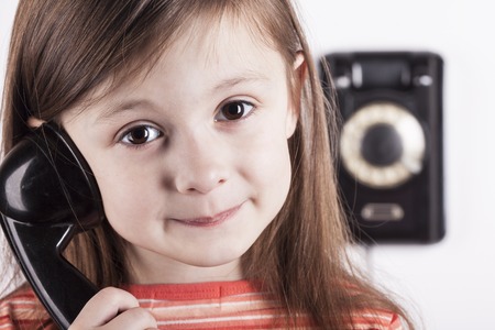 Portrait of a girl talking on phone on white background