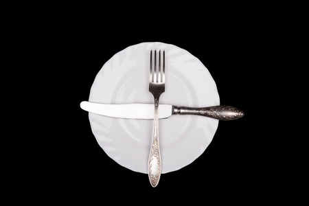 Etiquette sign. Plate, fork, knife top view isolated on black backgroundの写真素材