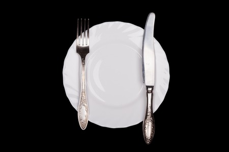 Etiquette sign. Plate, fork, knife top view isolated on black backgroundの写真素材