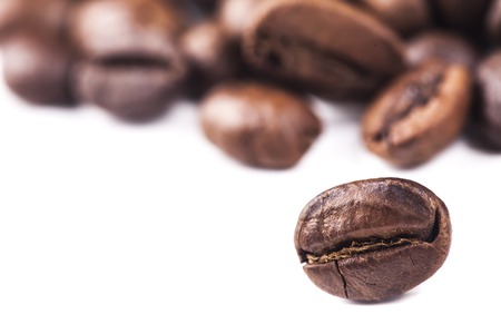 Rosted brown coffee beans lying on white background, selective focus, closeupの写真素材