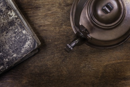 old kettle on a dirty wooden surface closeupの写真素材
