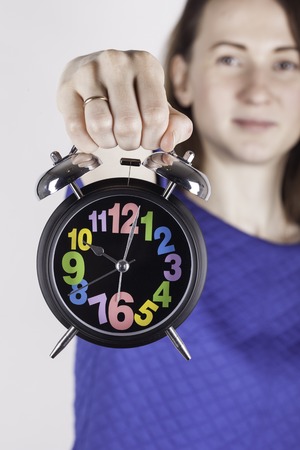 Young Girl holding an antique clock white textured background.