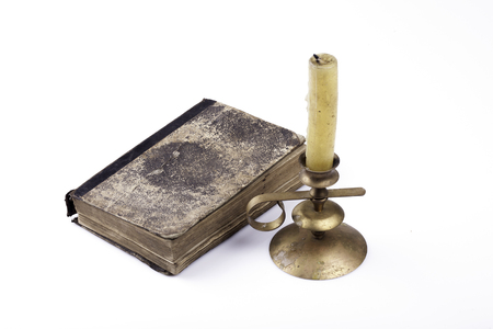 old book and candle closeup on white backgroundの写真素材