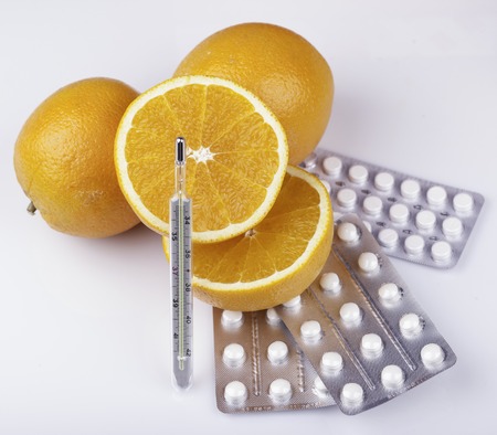 pills and thermometer on white background closeup