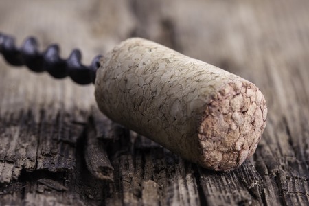 corkscrew and wine cork on wooden surface macro close upの写真素材
