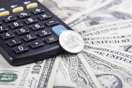black calculator and coin ruble on the background of American dollarsの写真素材