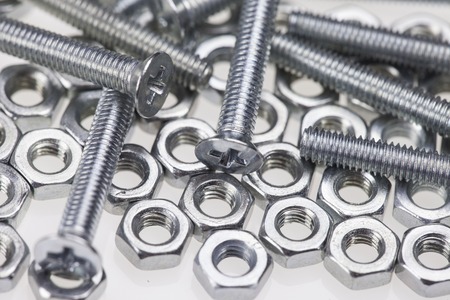 metal bolts and nuts close up on white backgroundの写真素材