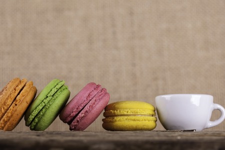 macaroons and cup coffee closeup on old wooden board vintage background side viewの写真素材
