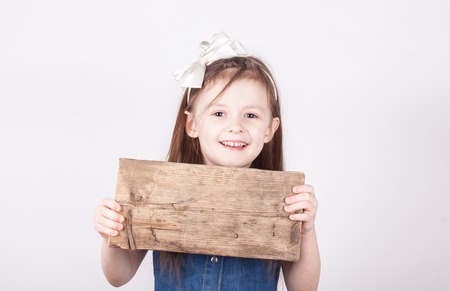 child girl with board for inscription in hands on white backgroundの写真素材