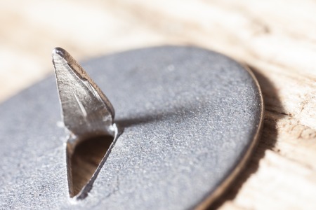 extra macro image of a metal pushpin on woodの写真素材