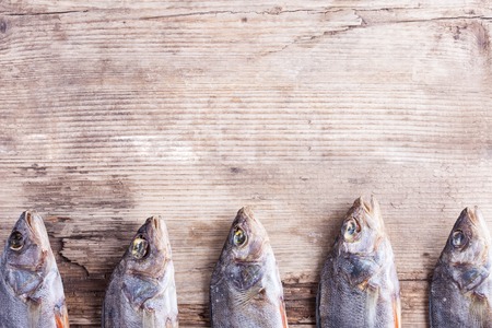 background of dried fish on the old wood Board closeupの写真素材
