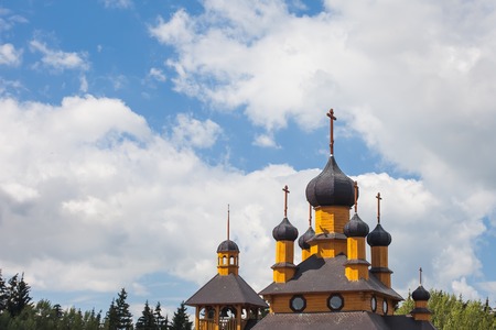 domes of the wooden Orthodox Church against the skyの写真素材
