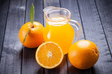 orange juice in the jug on the tableの写真素材