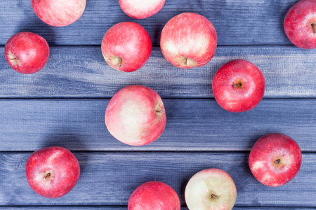 red ripe apples closeup on wooden table backgroundの写真素材