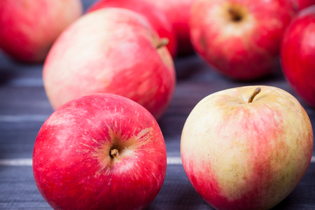 red ripe apples on wooden table close upの写真素材