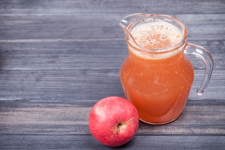 freshly squeezed Apple juice in the pitcher on the tableの写真素材