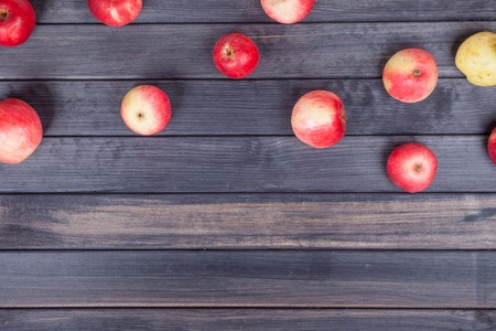 background of red apples on a black wooden table top viewの写真素材