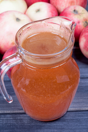 fresh squeezed juice in the pitcher on wooden table close upの写真素材