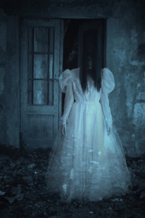 Spooky woman in a white dress in the field for designer