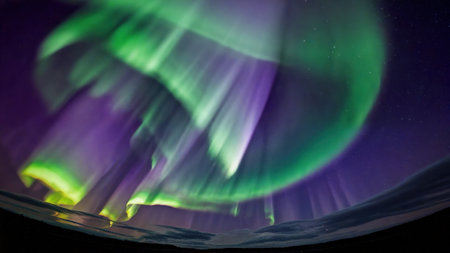 Vibrant green purple aurora borealis dancing in night sky close view northern lights majestic beauty aweの写真素材