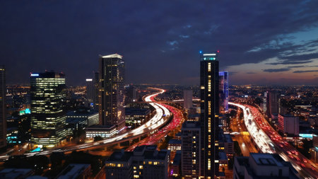 Aerial night view of illuminated city with vibrant highway light trails dynamic urban landscape and skyscrapersの写真素材