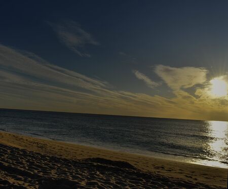 the blue sky with clouds threatening storm and sand on the beachの写真素材