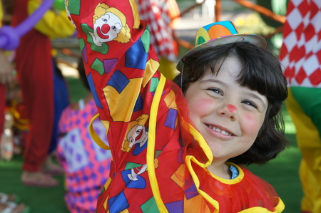 funny clown fancy dress child girl with colored foreground with bokeh effectの写真素材