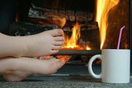 Child's feet at fireplaceの写真素材