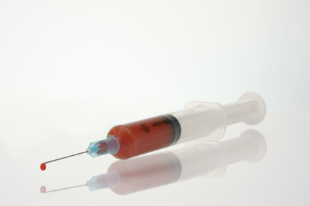 syringe with drop of blood, focus on dropの写真素材