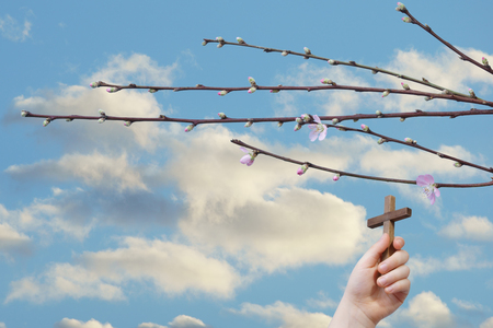 Easter background, religious concept. A child hand sustains a crossの写真素材