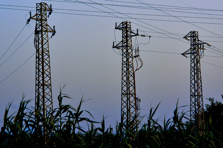 High-voltage tower. Electric powerlines on the dark sky.