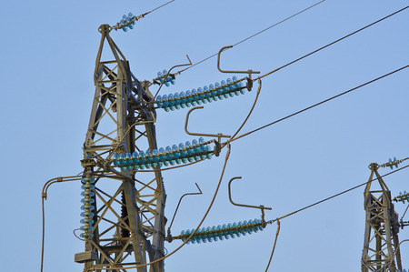 High-voltage tower. Electric powerlines on the blue sky.