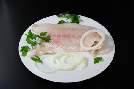 Fresh fish  perch, pangasius on white plate black background