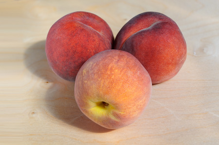Juicy ripe peach with Golden sideways on a wooden tableの写真素材
