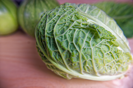 Fresh green cabbage among vegetables on wooden tableの写真素材