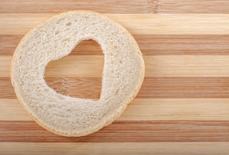 Heart shaped hole in a slice of breadの写真素材