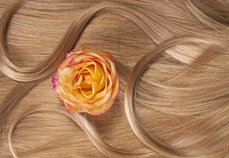 Wavy blonde human hair background with a flowerの写真素材