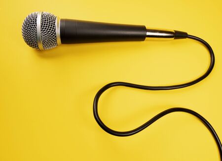 Microphone with curly cable on yellow backgroundの写真素材