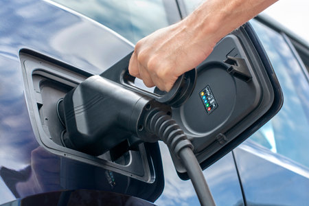 Human hand is holding electric car charging