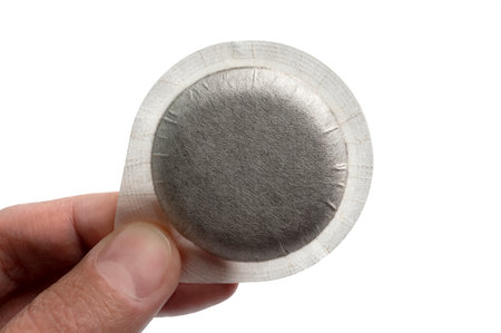 Close-up person holding coffee pod on white backgroundの写真素材