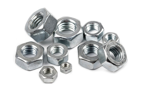 Close-up of steel screw nuts in different sizes on white background