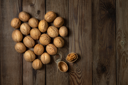 Walnuts in the form of a heart on a wooden table. Walnut kernel in shell. Copy Space.の写真素材