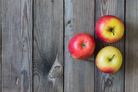Apples and pears lying on a natural wooden table. Copy space
